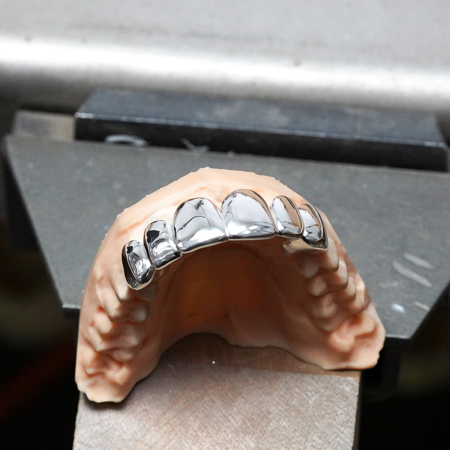 Dental model with metallic braces on a metal surface