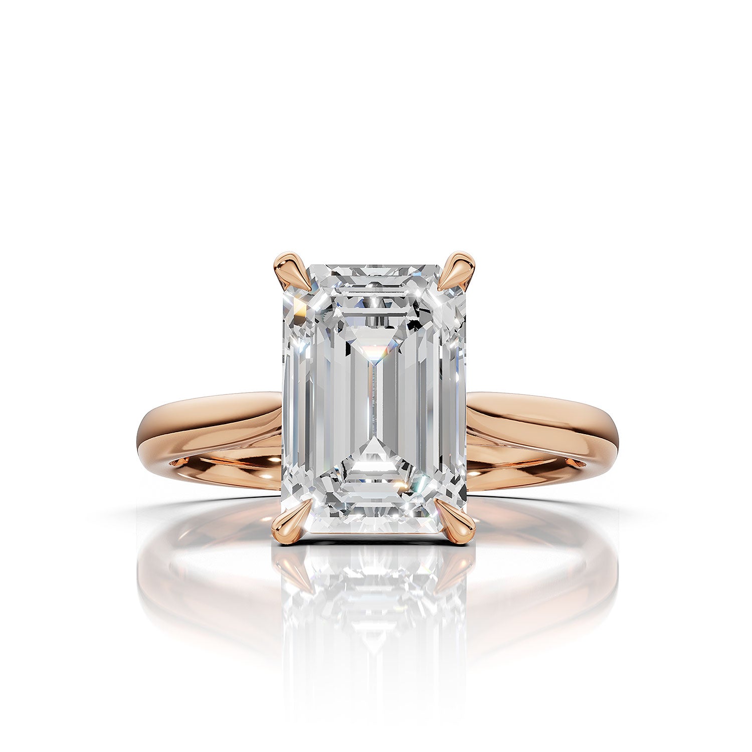 An emerald-cut diamond ring in a rose gold setting, shown on a clean white background with a soft reflection below.