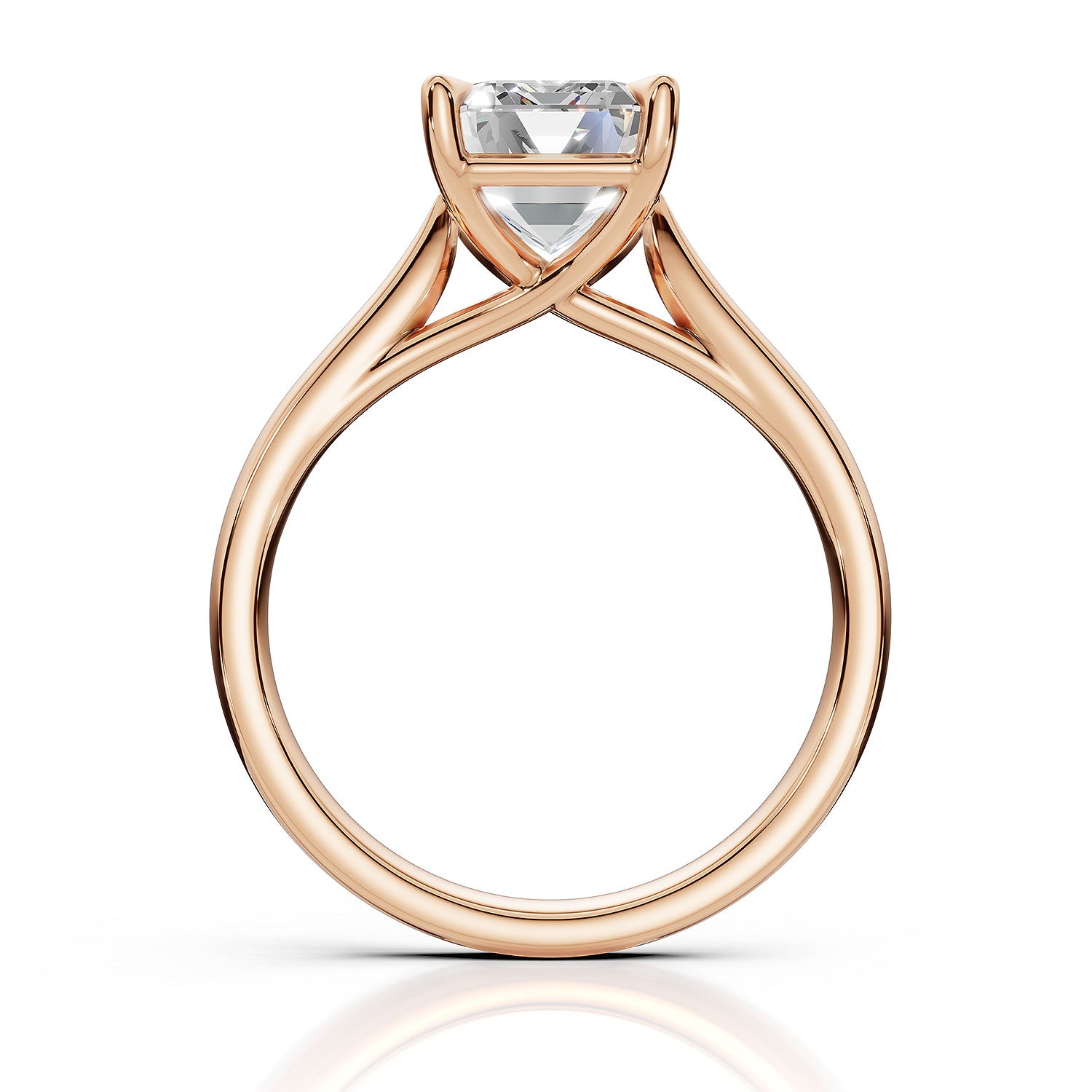 A rose gold solitaire engagement ring with a heart-shaped clear gemstone, shown on a clean white background with a soft reflection below.