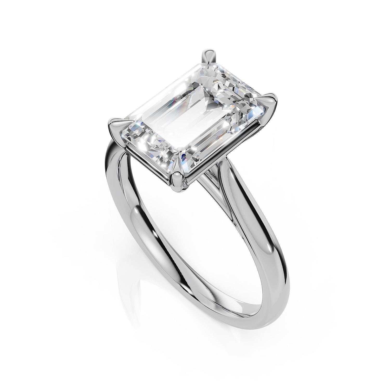 An emerald-cut diamond engagement ring in a polished silver-colored metal band, shown on a clean white background with a soft reflection.