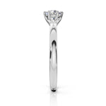 A classic six-prong diamond engagement ring in a polished white gold or platinum band, shown from a side profile view on a clean white background.