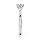 A classic six-prong diamond engagement ring in a polished white gold or platinum band, shown from a side profile view on a clean white background.