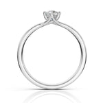 A silver solitaire engagement ring with a round brilliant-cut diamond set in a four-prong crown, shown on a clean white background with a soft reflection below.