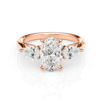 Rose gold ring with a central diamond and two smaller diamonds on a white background