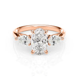 Rose gold ring with a central diamond and two smaller diamonds on a white background