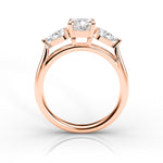 Rose gold ring with three diamonds on a white background