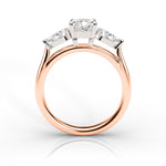 Rose gold ring with three diamonds on a white background