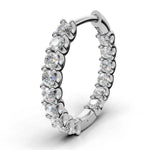 ILAYDA claw set diamond huggie earrings in white gold, 0.90ct total weight, close-up of the scalloped claw setting