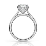 A classic solitaire engagement ring featuring a round brilliant-cut diamond set in a polished white gold or platinum band with a split shank design, shown on a clean white background with a subtle reflection.