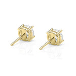 Gold stud earrings with clear gemstones on a white background