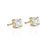 Gold stud earrings with clear gemstones on a white background
