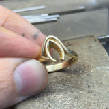 Our client's original yellow gold engagement ring before remodelling, shown on the workshop bench
