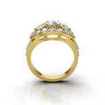 A yellow gold ring with a cluster of clear gemstones on the top, shown from a front-facing angle against a white background with a soft reflection below.