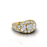 A yellow gold ring featuring a large oval cluster of round-cut clear gemstones, including a prominent center stone, set against a clean white background with a soft reflection.