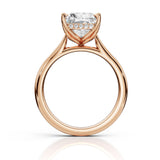 Rose gold diamond ring with a heart-shaped clear center stone and small accent diamonds along the band, shown on a white background with a soft reflection.