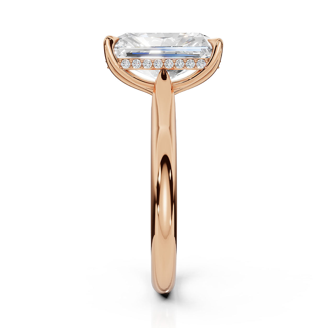A rose gold engagement ring featuring a large rectangular emerald-cut clear center stone and a halo of small round-cut stones on the band, shown against a solid white background.
