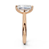 A rose gold engagement ring featuring a large rectangular emerald-cut clear center stone and a halo of small round-cut stones on the band, shown against a solid white background.