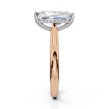 An engagement ring featuring a large rectangular emerald-cut diamond on a polished rose gold band with a halo of small round diamonds, shown against a solid white background.