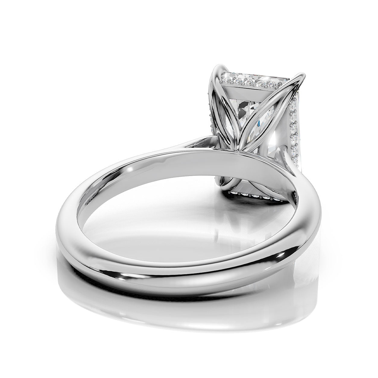 A silver-colored diamond ring with a square-cut center stone and a halo setting, shown from a three-quarters perspective on a clean white background with a soft reflection.