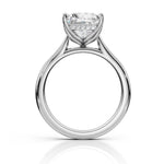 A silver-tone solitaire engagement ring with a round brilliant-cut diamond center stone and a row of small accent diamonds, shown on a clean white background with a soft reflection below.