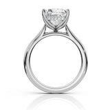 A silver-tone solitaire engagement ring with a round brilliant-cut diamond center stone and a row of small accent diamonds, shown on a clean white background with a soft reflection below.