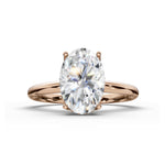 An oval-cut diamond engagement ring in a rose gold setting, shown on a clean white background with a soft shadow.
