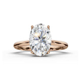 An oval-cut diamond engagement ring in a rose gold setting, shown on a clean white background with a soft shadow.