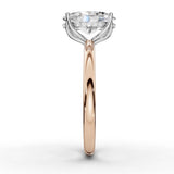 A rose gold engagement ring featuring a large round-cut diamond center stone in a four-prong setting, accented by small diamonds along the shoulders, shown on a clean white background.