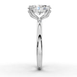 A classic solitaire engagement ring featuring a round brilliant-cut diamond set in a polished white gold or platinum band with a halo of smaller diamonds, shown on a clean white background.