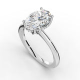 A silver engagement ring featuring a large oval-cut clear gemstone in a prong setting, accented by a halo of small round stones on a clean white background.