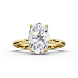 An oval-cut diamond engagement ring with a yellow gold band, shown on a clean white background with a soft shadow.