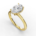 A yellow gold engagement ring featuring a large oval-cut clear gemstone in a prong setting with small accent diamonds along the halo, shown on a clean white background.