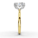 A yellow gold and white gold diamond engagement ring with a round brilliant-cut center stone and a halo of small diamonds, shown on a clean white background.