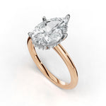 A pear-cut diamond engagement ring with a rose gold band and a halo of small diamonds, shown on a clean white background.