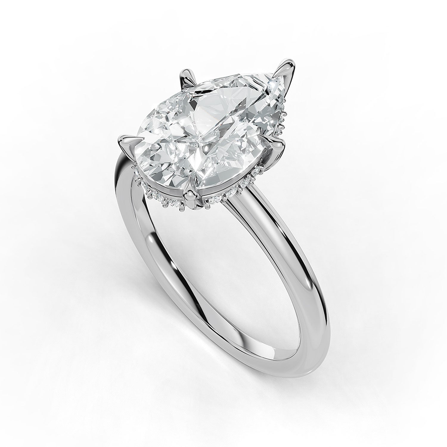 A pear-cut diamond engagement ring in a polished silver-toned setting with a halo of small diamonds, shown on a clean white background.
