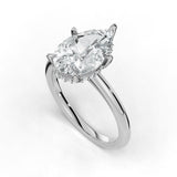 A pear-cut diamond engagement ring in a polished silver-toned setting with a halo of small diamonds, shown on a clean white background.