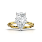 A pear-cut diamond engagement ring with a yellow gold band and white gold prongs, centered on a clean white background.